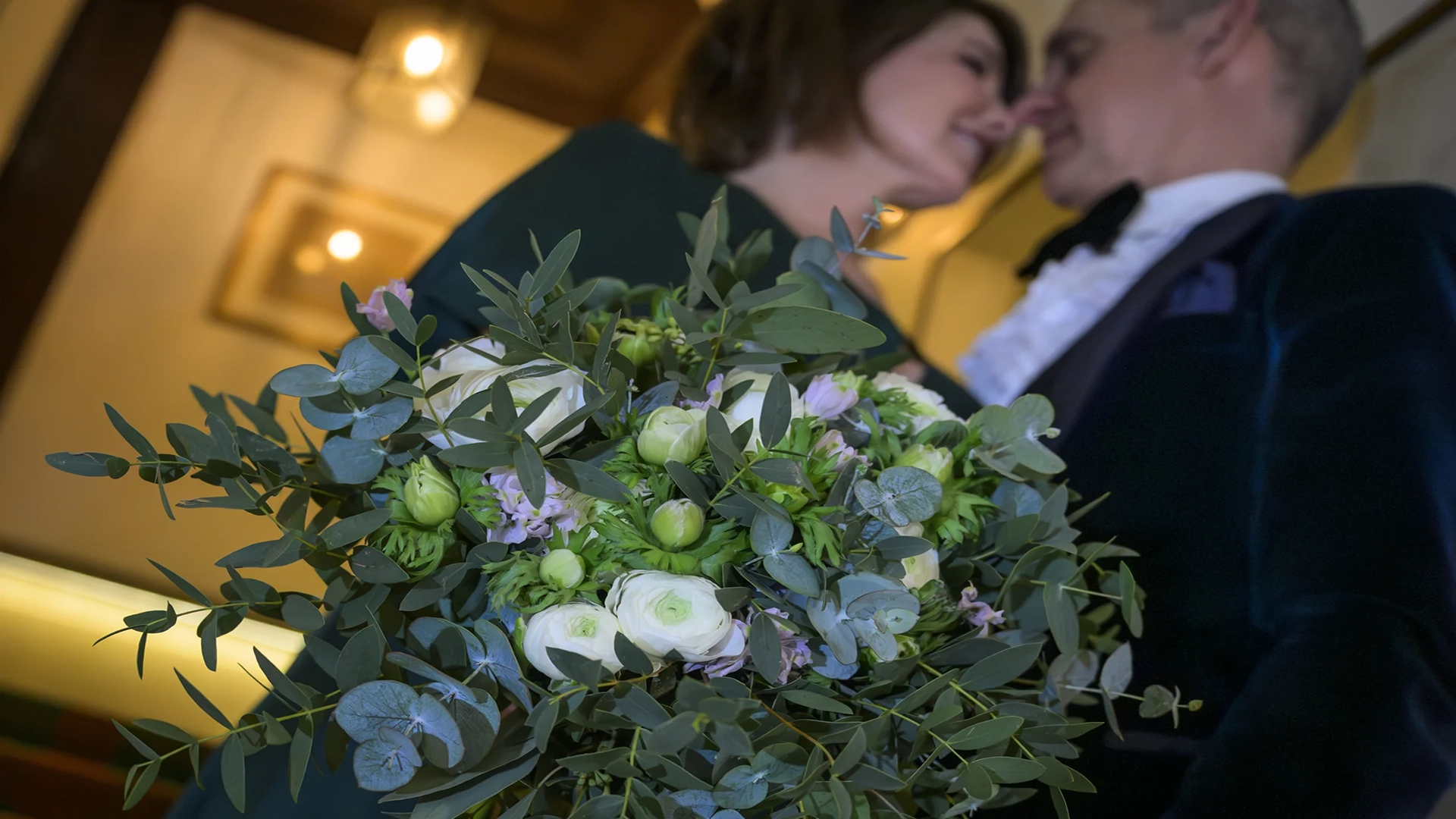 Bouquet with wedding couple kissing
