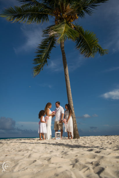 wedding photography intimate ceremony with couple and 2 children under a palm tree on the beach
